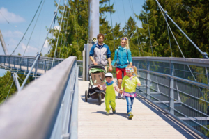 Ein junges Paar mit zwei kleinen Kindern läuft über den Skywalk.