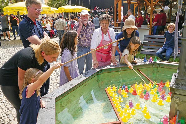 Scheidegg Marktfest Viele Besucher auf dem Marktfest in Scheidegg spielen im Brunnen Entenfischen.
