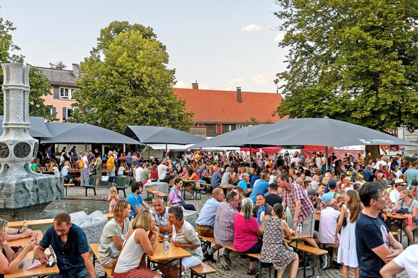 Stadtfest-Lindenberg_1 Volle Bierbänke mit Menschen, die das Kinderfest Lindenberg besuchen.