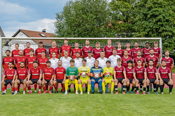 FC Lindenberg Mannschaft Die Mannschaft des FC Lindenberg, fotografiert vor dem Tor, im Hintergrund Bäume und ein Haus.